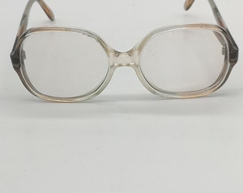 May include: A pair of clear, rectangular eyeglasses with brown frames. The frames have a slight curve to them.