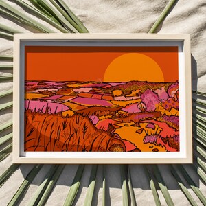 May include: A framed illustration of a sunset over a landscape with rolling hills and fields in shades of orange, pink, and green. The sun is a large orange circle in the sky.