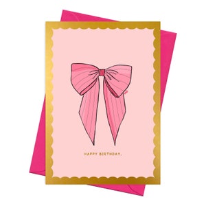 May include: Pink birthday card with a gold border and a pink bow with white stripes. The card says "Happy Birthday."