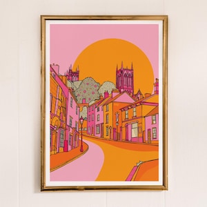 May include: A digital illustration of a pink and orange cityscape with a large orange sun in the background. The buildings are lined up on a winding street leading to a tall church with a pointed spire.