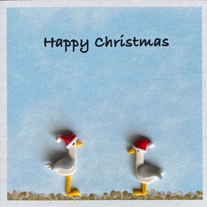 Jolies mouettes portant des chapeaux de Noël Carte de Noël avec des décorations en argile faites main.