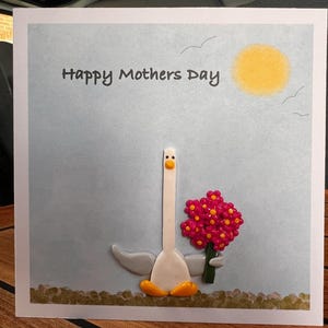 Carte de fête des Mères mouette tenant un bouquet avec des décorations faites main en argile polymère.