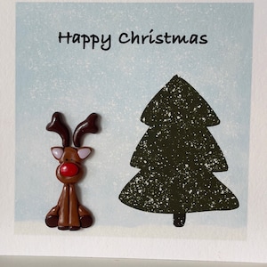 Jolie carte de Noël avec un renne et une décoration en argile faite main
