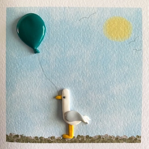 May include: A white seagull with yellow feet and a teal blue balloon on a string against a light blue background with a yellow sun and white birds.