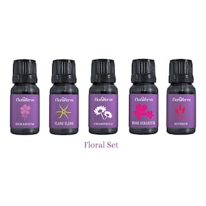 Könnte beinhalten: Ein Set aus fünf ätherischen Ölflaschen mit schwarzen Deckeln und lila Etiketten. Jedes Etikett zeigt eine andere Blumenillustration und den Namen des Öls: Geranie, Ylang Ylang, Kamille, Rosengeranie und Ysop. Der Text "Floral Set" steht unter den Flaschen.