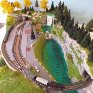 Model railway with a realistic forest mountain layout, with lakes and waterfalls in N scale.