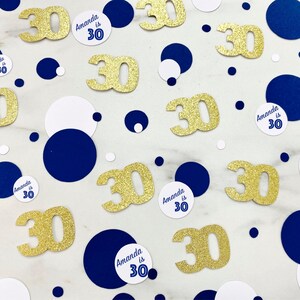 May include: Gold glitter confetti with the number 30 and white circles with the text "Amanda is 30" on a white background with navy blue circles.