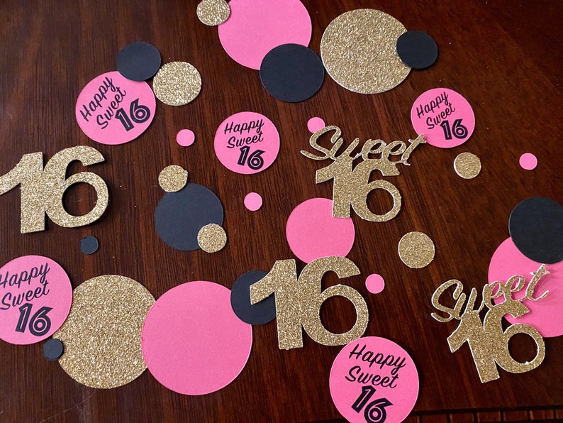 May include: Gold glitter confetti with pink and black circles and the text "Happy Sweet 16" and "Sweet 16" in black and gold glitter.