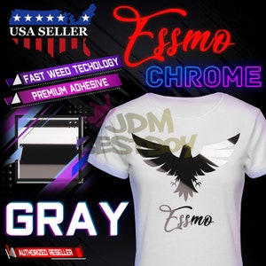 May include: A white t-shirt with a black and white chrome eagle graphic and the text "Essmo Chrome" in red and blue. The text "JDM" is visible in the background. The shirt is labeled "Gray" and "Authorized Reseller".