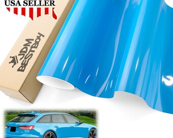 May include: A roll of bright blue vinyl car wrap film. The film is glossy and has a smooth surface. The image also shows a blue car wrapped in the same film.