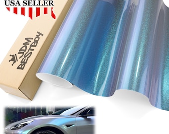 May include: A roll of iridescent blue vinyl wrap with a shimmering finish. The product is next to a cardboard box with the text "JDM BESTBOY" and "USA SELLER" printed on it. A car with the same color wrap is shown in the bottom corner.