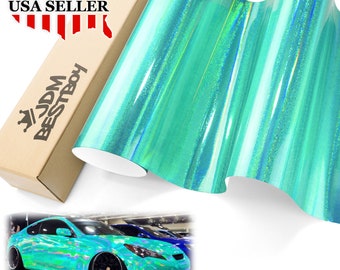 May include: A roll of turquoise iridescent vinyl car wrap with a holographic finish. The vinyl is shown wrapped around a car in the image. The text "JDM BESTBOY" is on the box.