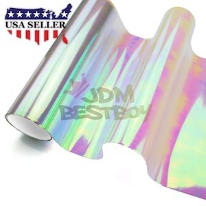 May include: A roll of iridescent holographic vinyl film with a rainbow sheen. The film is rolled up and partially unrolled, revealing the iridescent colors. The text "JDM BESTBOY" is printed on the film.