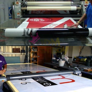 May include: A large format printer in operation, producing a sign with red and white graphics. The machine is rolling the printed material, with a black and white roll of material in the foreground. The word "future" is visible on the sign.