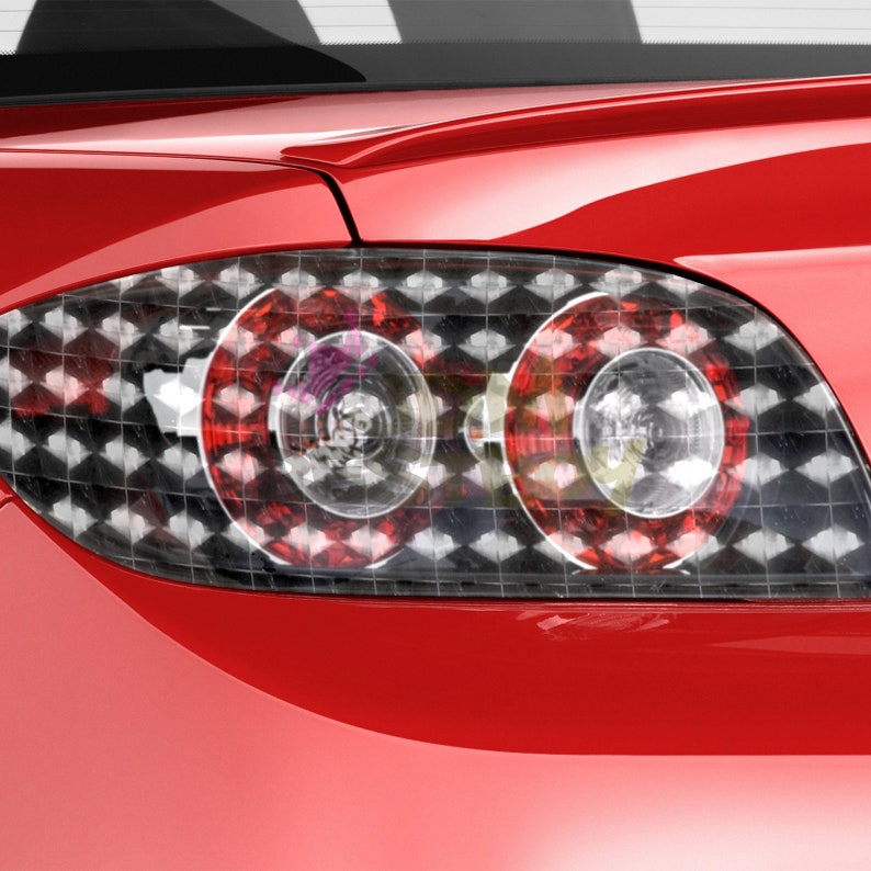 Puede incluir: El piloto trasero de un coche rojo con un patr&oacute;n de cuadros negros y blancos superpuesto. El piloto trasero est&aacute; hecho de pl&aacute;stico transparente y tiene una luz roja y blanca en su interior.