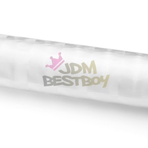 Puede incluir: Un rollo blanco de vinilo con una corona rosa y el texto "JDM BESTBOY" impreso en &eacute;l.