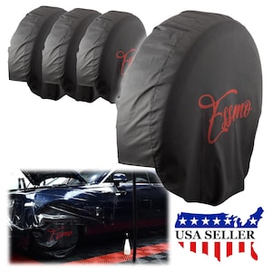 May include: Set of four black spare tire covers with red embroidered text "Essmo". The covers are made of a durable fabric and are designed to protect your spare tire from the elements. The covers are shown on a black car with a white background.