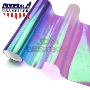 May include: A roll of iridescent holographic vinyl film with a purple, blue, and green color shift. The film is rolled up and has a white core. The text "JDM BESTBOY" is visible on the film.