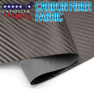 May include: A close-up of a black carbon fiber fabric with a woven pattern. The fabric is folded over, revealing a gray backing. The text "CARBON FIBER FABRIC" is printed in blue letters on a white background.
