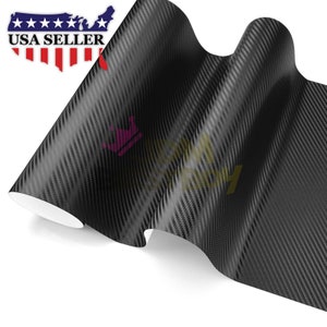 May include: Black carbon fiber vinyl sheet with a woven texture. The sheet is rolled up and has a slight curve.