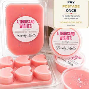 May include: A collection of pink soy wax melts in heart shapes and round containers, labelled A THOUSAND WISHES by Lovely Melts. The packaging includes text stating PAY POSTAGE ONCE, No matter how many items you order ACROSS OUR SHOP, Lovely Melts.