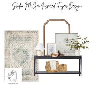 Op de afbeelding: Een Studio McGee-geïnspireerd ontwerp voor een hal met een zwarte consoletafel met twee geweven manden, een witte lamp met een beige lampenkap, een ingelijst drukwerk, een groot abstract schilderij en een vaas met groen. De consoletafel staat op een tapijt met een patroon.