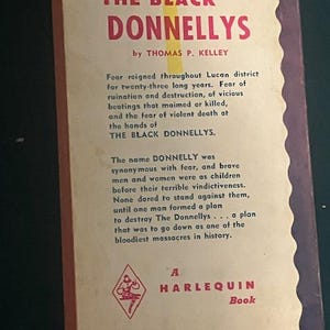 Pu&ograve; includere: La copertina posteriore di un libro tascabile vintage intitolato "THE BLACK DONNELLYS" di Thomas P. Kelley. La copertina &egrave; color crema con accenti rossi e viola e presenta il testo che descrive la trama del libro.