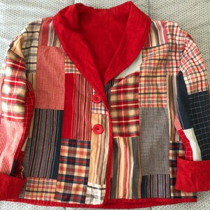 Peut inclure: Une veste en patchwork compos&eacute;e de divers carr&eacute;s de tissu &agrave; carreaux et &eacute;cossais dans des tons rouge, bleu, beige et blanc. La veste pr&eacute;sente un col ch&acirc;le rouge uni, des poignets rouges et deux boutons rouges sur la fermeture avant &agrave; manches longues.