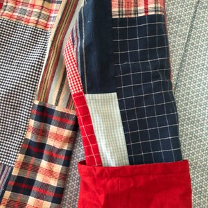 Peut inclure: Une veste &agrave; manches longues compos&eacute;e d'un patchwork de tissus vari&eacute;s, incluant des motifs &agrave; carreaux rouges, blancs et bleus, des quadrillages bleu marine et des vichys bleu clair. La manche pr&eacute;sente un poignet rouge uni contrastant.
