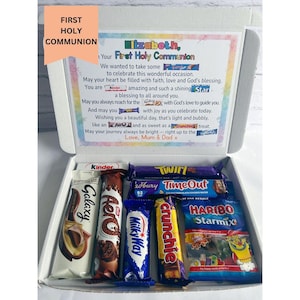 May include: A white box filled with assorted candy bars and a card. The card reads "First Holy Communion" and includes a personalized message. Candy brands include Galaxy, Aero, Milky Way, Crunchie, and Haribo Starmix.