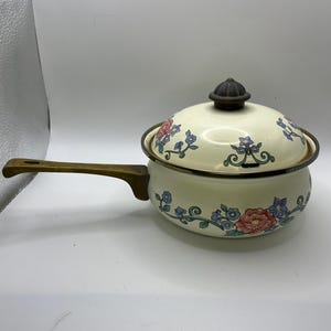 May include: A set of three ceramic mugs with a speckled, matte finish. The mugs are in shades of cream, light gray, and dark gray. Each mug has a simple, minimalist design and a rounded handle. The mugs are stacked on top of each other.