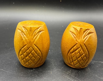 Salero y pimentero vintage de madera tallada a mano con forma de piña, estilo tiki de mediados de siglo.