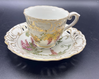 Conjunto de xícara e pires Vintage Walls China com borda vazada e motivo de uvas roxas.