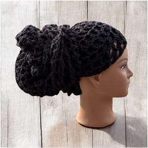 May include: Black crochet hair bonnet with a loose, open weave. The bonnet is worn on a mannequin head.