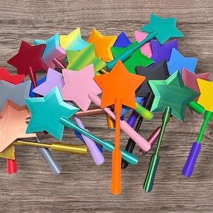 May include: A collection of numerous star-shaped wands in a variety of vibrant colors including red, orange, yellow, green, blue, purple, pink, and black. Each wand features a five-pointed star attached to a slender handle, creating a colorful display.