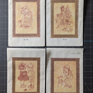 May include: Four rectangular paper prints featuring sepia-toned line drawings of children in ornate frames. Each print displays a unique scene and a reference code: R-219, R-211, R-201, and R-220. The illustrations depict domestic activities.