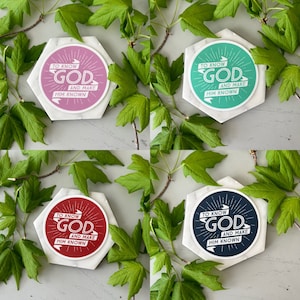 May include: Four hexagonal coasters with a white background and a round sticker with the text "To Know God and Make Him Known" in white lettering on a colored background. The coasters are pink, green, red, and blue.