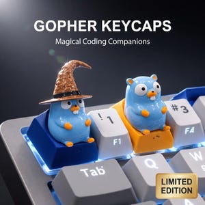 Könnte beinhalten: Nahaufnahme einer Tastatur mit individuellen Keycaps. Die Keycaps zeigen blaue Cartoon-Gophers, einer davon trägt einen braunen Zaubererhut. Der Text "GOPHER KEYCAPS" und "Magical Coding Companions" sind zu sehen. Ein goldener "LIMITED EDITION" Aufkleber ist sichtbar.