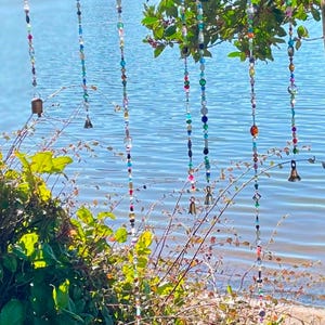Sparkly decorative glass beaded strands with brass bell