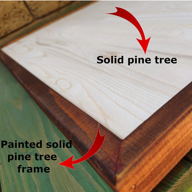 May include: A close-up of a wooden sign with a natural pine tree surface and a painted solid pine tree frame. The frame is a dark brown color.