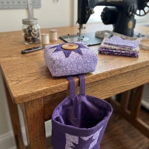 May include: A set of three ceramic mugs with a speckled, matte finish. The mugs are in shades of cream, light gray, and dark gray. Each mug has a simple, minimalist design, perfect for coffee or tea.