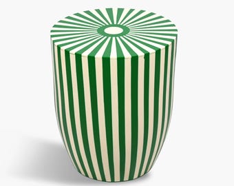 May include: A green and white striped cylindrical stool with a sunburst design on the top.