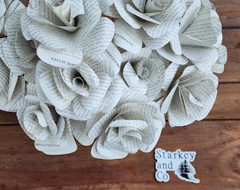 May include: A heart-shaped arrangement of paper roses made from the pages of books. The roses are white and have a vintage look. The text on the pages includes the title "Mansfield Park" and the author "Jane Austen". A small sticker with the text "Starkey and Co" is in the lower right corner of the image.