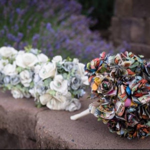 May include: Two wedding bouquets, one made of white paper flowers and the other made of colorful comic book pages.