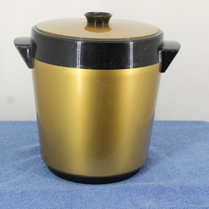 May include: A gold and black plastic ice bucket with a lid and two handles.