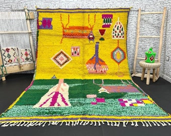 Puede incluir: Una alfombra marroquí colorida con fondo amarillo y verde. La alfombra presenta un diseño geométrico con una variedad de colores, incluyendo rosa, morado, naranja y azul. La alfombra tiene un borde con flecos.