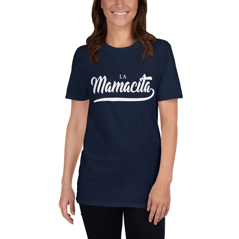 Puede incluir: Una camiseta azul marino con un gr&aacute;fico blanco que dice "LA Mamacita" en una fuente cursiva.