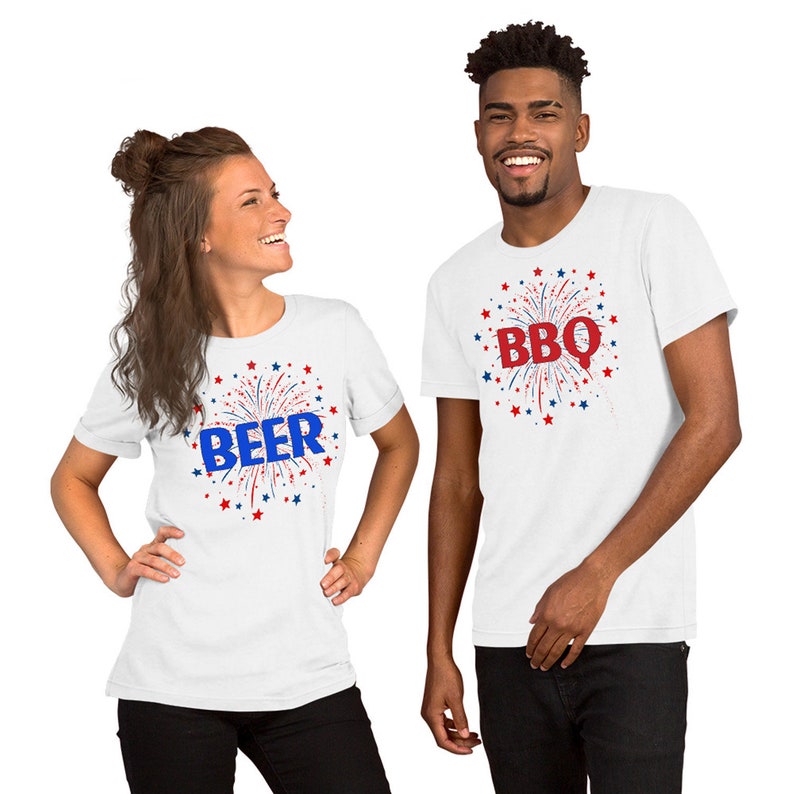 May include: Two white t-shirts with red, white, and blue firework designs. One shirt says "BEER" and the other says "BBQ".