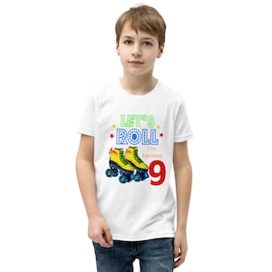 May include: White t-shirt featuring the text "Let's Roll I'm turning 9" and a graphic of yellow roller skates with blue wheels and flames. The number 9 is in red. The shirt is for a child.