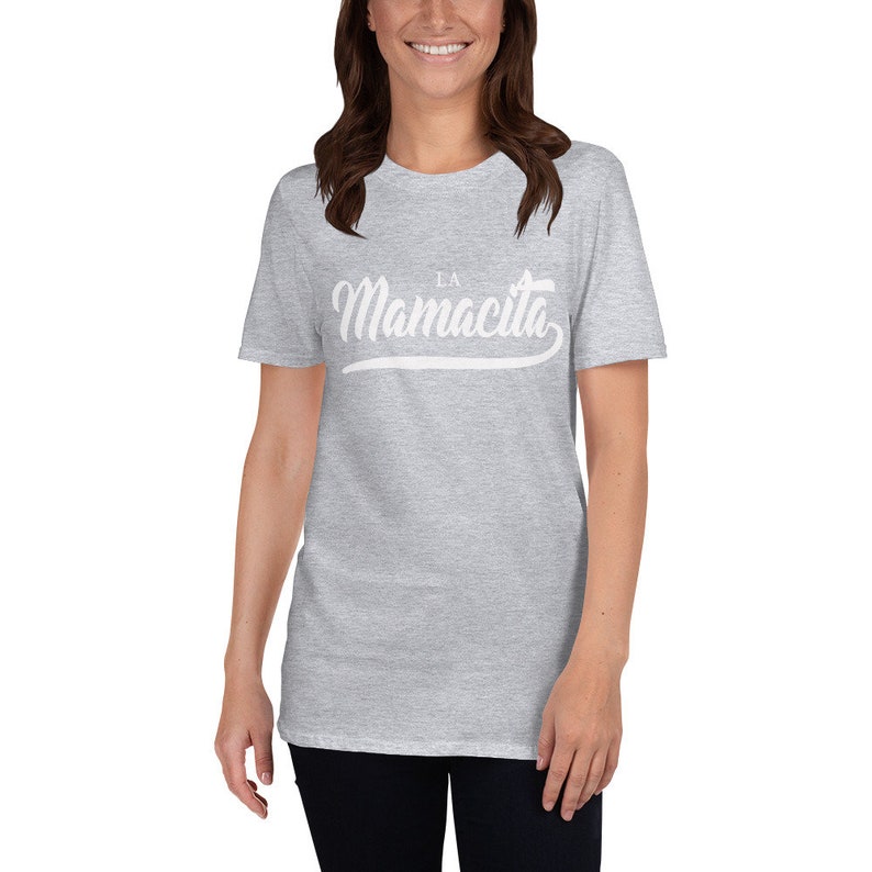 Puede incluir: Una camiseta gris jaspeada con un gr&aacute;fico blanco que dice "La Mamacita" en una fuente cursiva.